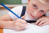Close up of a serious schoolgirl writing something