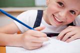 Close up of a smiling schoolgirl writing something