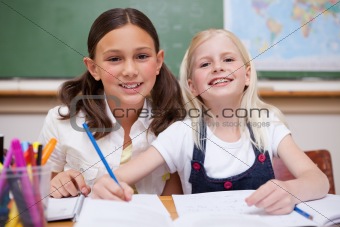 Smiling pupils working together on an assignment