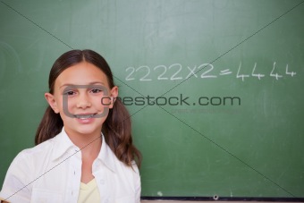 Schoolgirl posing in front of a chalkboard