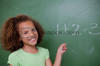Cute schoolgirl pointing at an addition