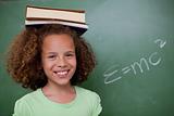 Happy schoolgirl holding her book on her head