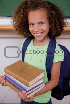 Portrait of a schoolgirl holding her books