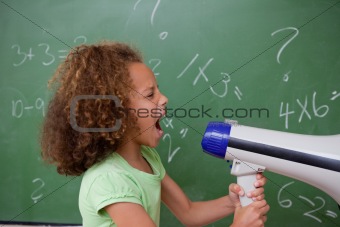 Side view of a schoolgirl screaming through a megaphone