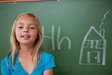 Blonde schoolgirl posing in front of a blackboard