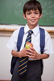 Portrait of a schoolboy holding an apple
