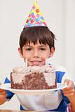 Boy presenting birthday cake