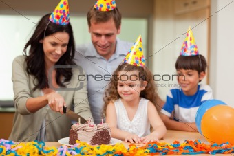 Mother cutting birthday cake