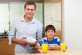 Father and son having cereals and orange juice