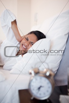 Side view of woman getting ungently woken by alarm clock