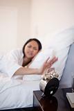 Alarm clock being deactivated by woman