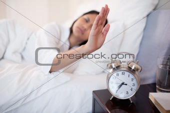 Alarm clock being turned off by woman