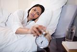 Woman annoyed by ringing alarm clock