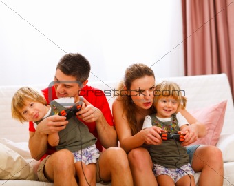 Family spending time together and playing on console at home