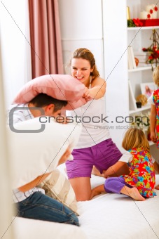 Happy family having a pillow fight in bed
