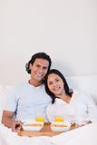Happy couple having breakfast in the bed