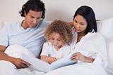 Happy family enjoys reading a book together
