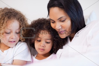 Woman sitting on the bed with her daughters
