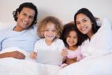 Family together on the bed with laptop