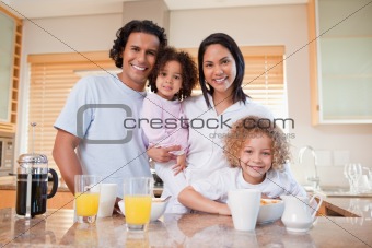 Happy family standing in the kitchen together