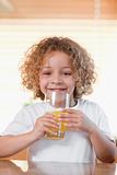 Happy girl drinking orange juice in the kitchen