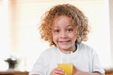 Girl with a glass of orange juice in the kitchen