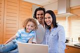 Cheerful family surfing the internet in the kitchen together
