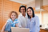 Joyful family surfing the internet in the kitchen together