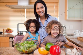 Mother and her daughters preparing salad in the kitchen together