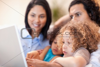 Cheerful family using laptop together