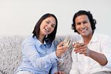 Couple celebrating with sparkling wine on the couch