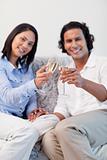 Couple celebrating with sparkling wine in the living room