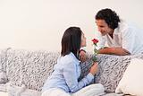 Woman got a rose from her boyfriend in the living room