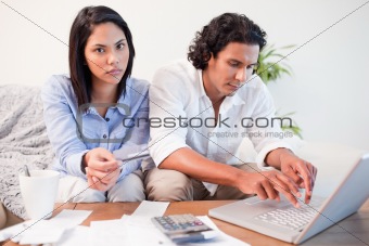 Couple checking their bank accounts online in the living room