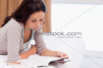 Woman reading magazine on the bed