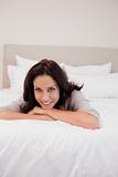 Smiling woman relaxing on her bed