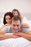 Cheerful family relaxing on the bed together