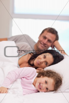 Family lying on the bed together