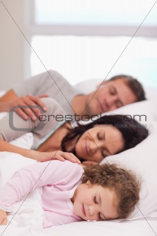 Family sleeping on the bed