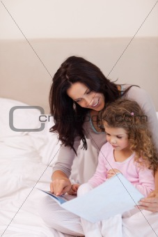 Mother reading bedtime story for her daughter