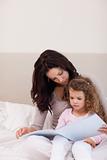 Mother reading a story for her little daughter