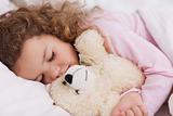 Girl hugging her teddy while sleeping
