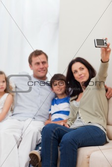 Mother taking family photograph on the sofa