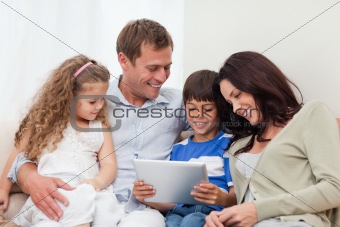 Family using tablet on the sofa