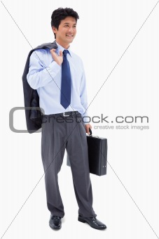 Portrait of a smiling businessman holding a briefcase and his jacket over his shoulder