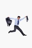 Cheerful businessman jumping while holding his jacket and a briefcase
