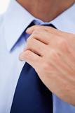 Close up of a businessman fixing his tie