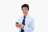 Smiling businessman sending a text message