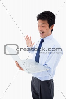 Portrait of a businessman waving at a notebook