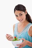 Portrait of a brunette woman eating a salad